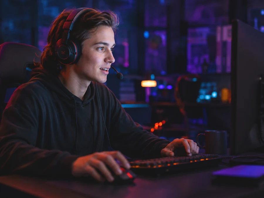 A gamer at a computer in a dark room.